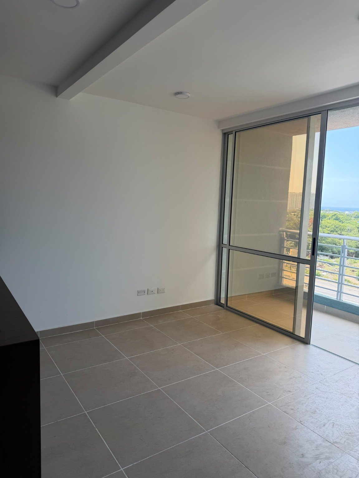 Sala sin decorar con salida al balcón